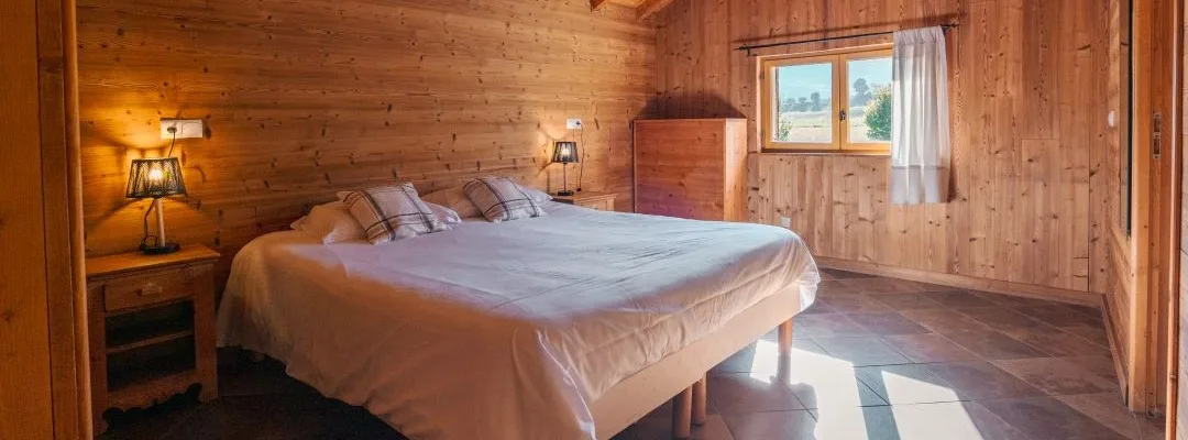 Chambre du gîte Rochette avec deux lits et fenêtre donnant sur la campagne