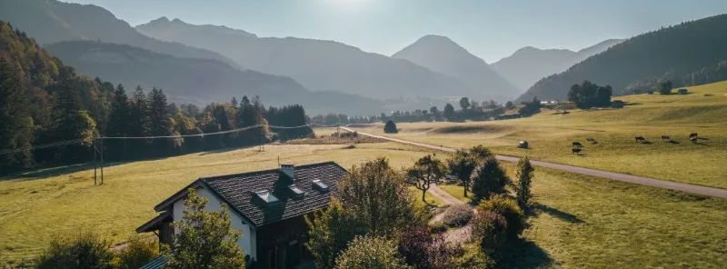 Vue aérienne du gîte le Moulin isolé au milieu des prairies avec montagnes des Bauges en fond