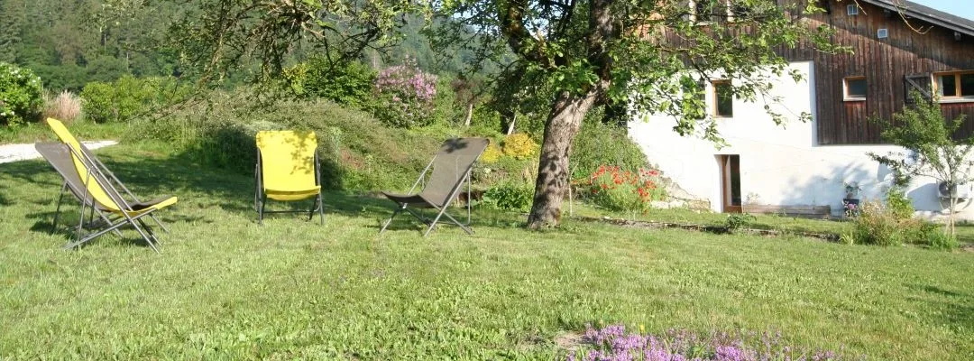 Jardin arboré avec chaises longues pour se détendre face aux prairies environnantes