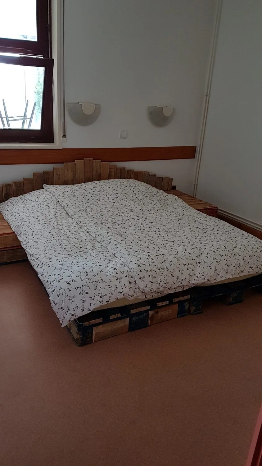 Chambre avec grand lit double sur sommier en palettes de bois