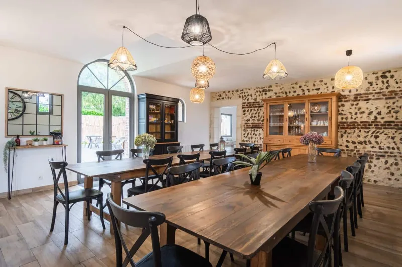 Grande salle à manger avec deux longues tables en bois pouvant accueillir un large groupe