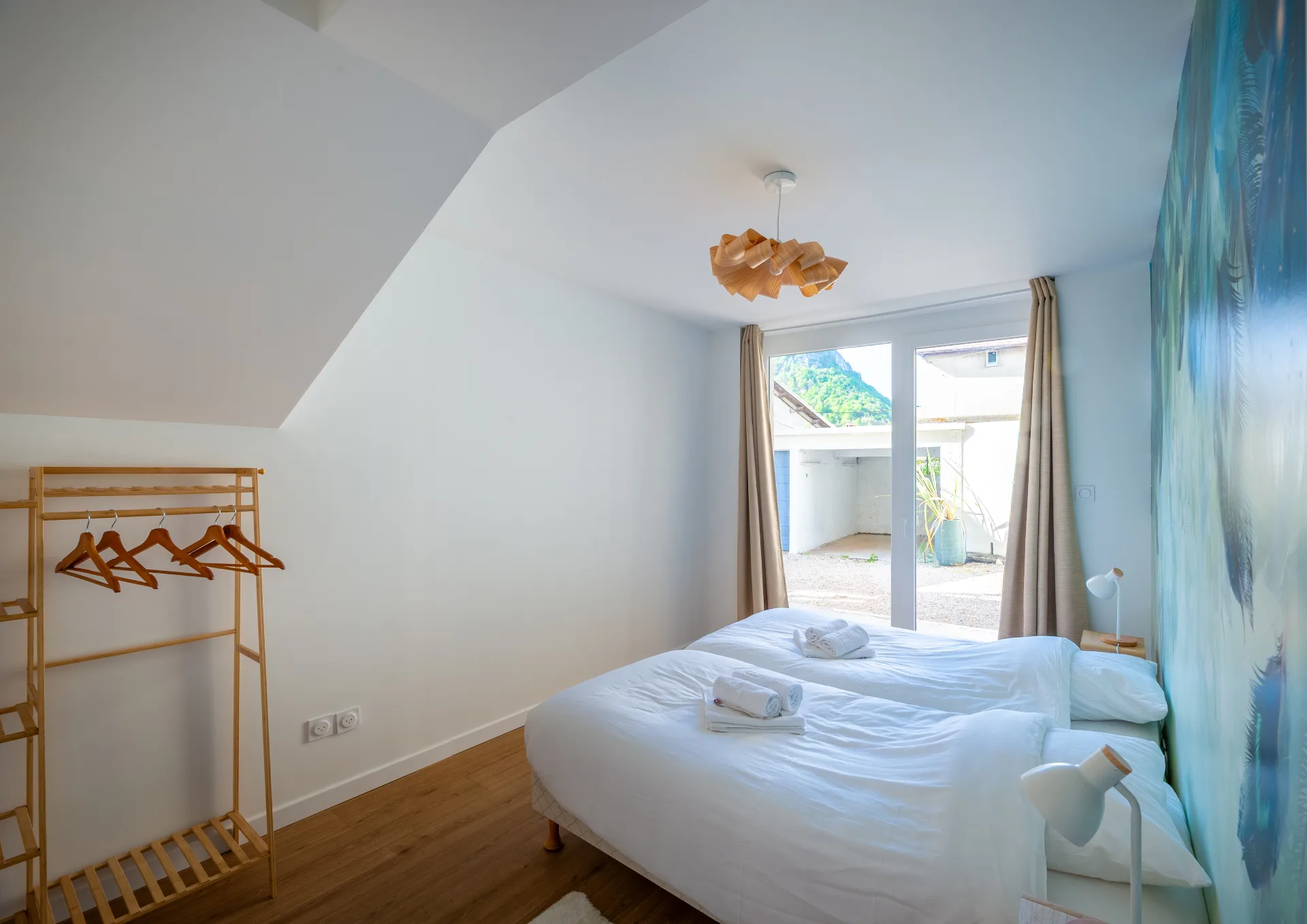 Chambre lumineuse avec lits doubles et linge de lit sobre
