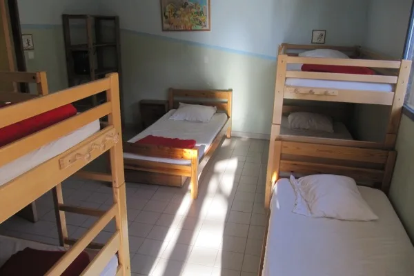 Chambre avec lits superposés en bois et linge de lit rouge et blanc