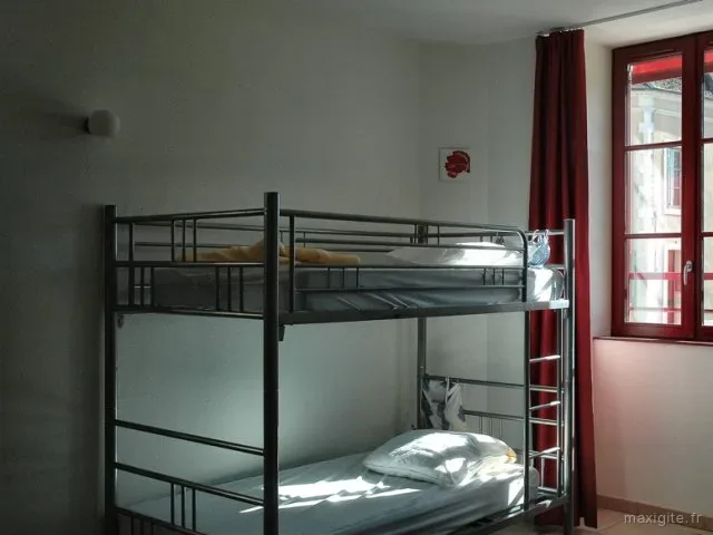 Cour intérieure sous arcade avec porte-fenêtre rouge et coin détente