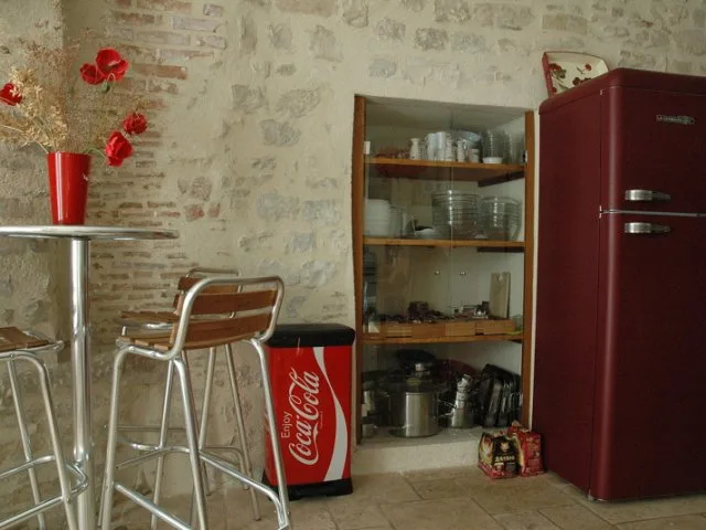 Coin cuisine avec rangements vitrés, vaisselle et réfrigérateur