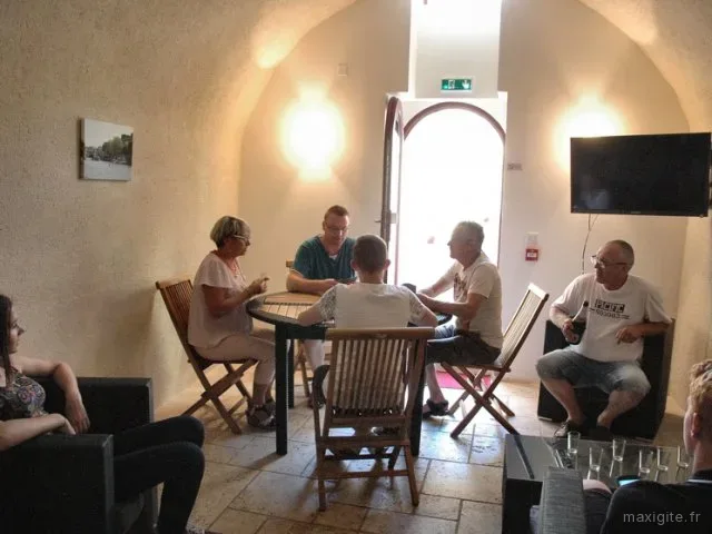 Salon voûté en pierre avec télévision et coin salon pour les soirées de groupe