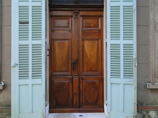 Entrée de la propriété avec grande porte en bois et volets bleu pâle