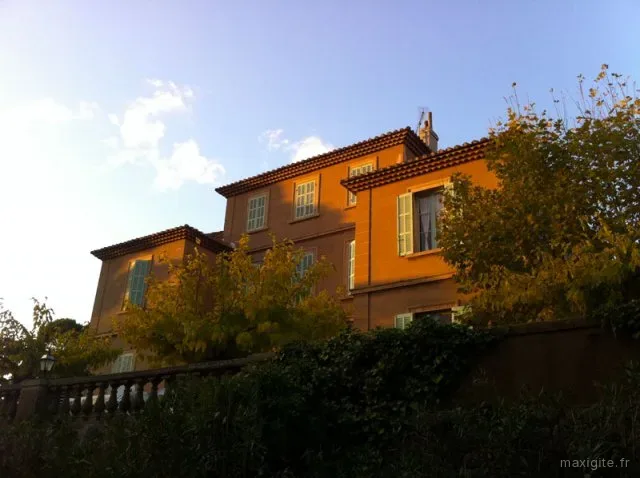 Façade de la bastide éclairée par la lumière dorée du soir, volets provençaux