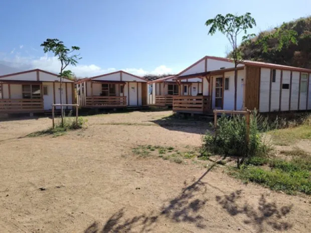 Rangée de chalets d'hébergement avec terrasses en bois, entourés de verdure