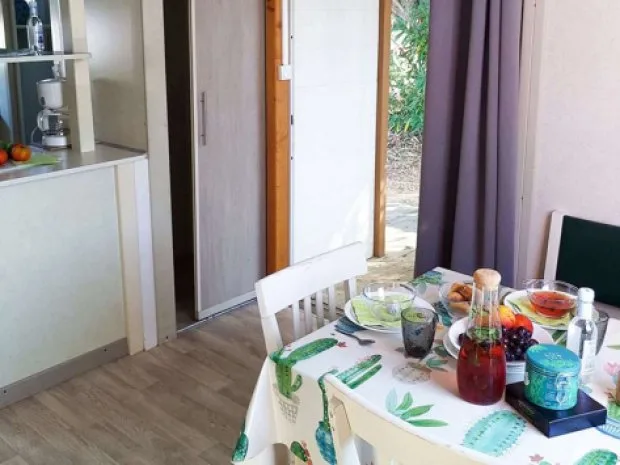 Coin repas dans un chalet avec table dressée et accès direct à la terrasse extérieure