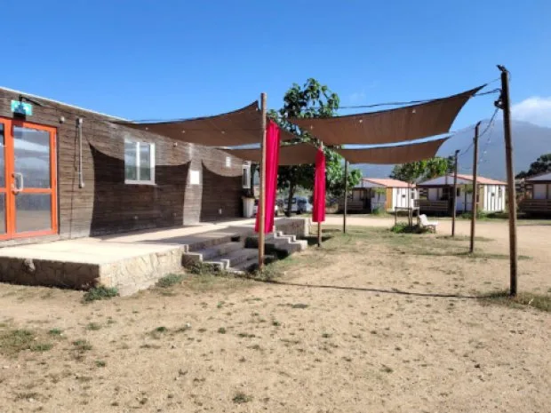 Chalets avec terrasse et voiles d'ombrage colorées, vue sur les montagnes corses