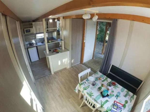 Intérieur d'un chalet avec kitchenette équipée et coin repas lumineux