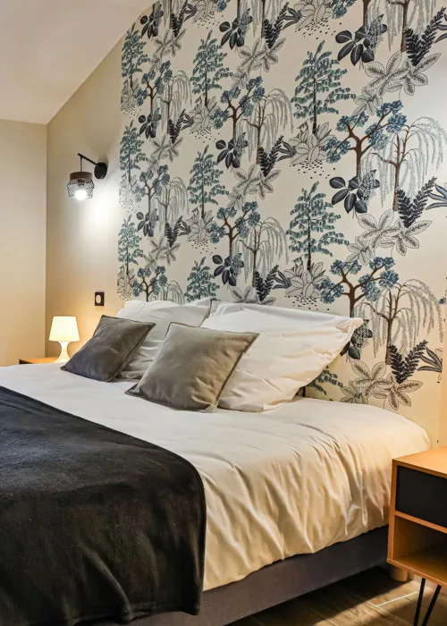 Chambre double avec tête de lit fleurie et lampes de chevet en bois