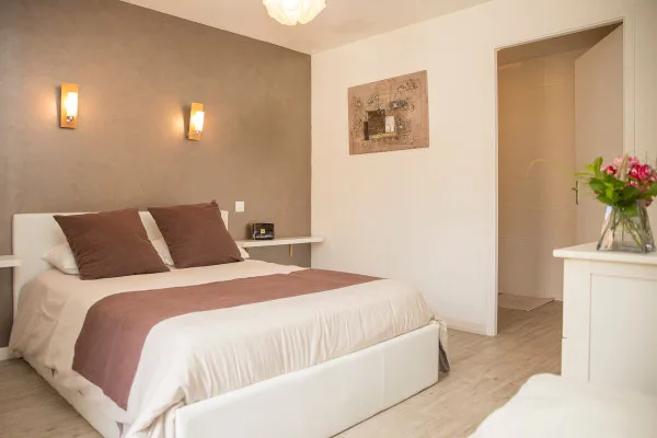 Chambre spacieuse avec tête de lit taupe et bouquet de fleurs