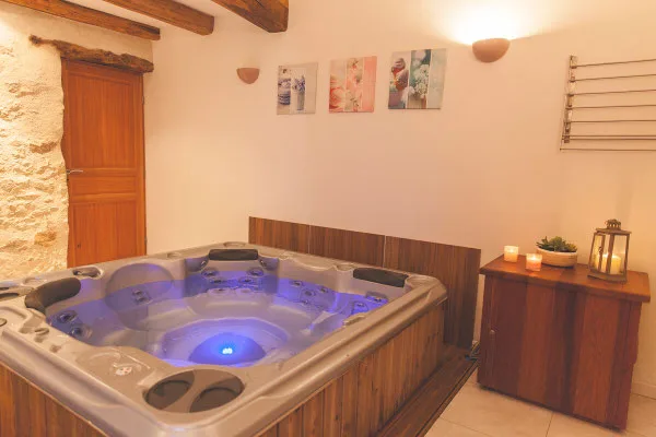 Jacuzzi privé intérieur avec ambiance tamisée et coin détente