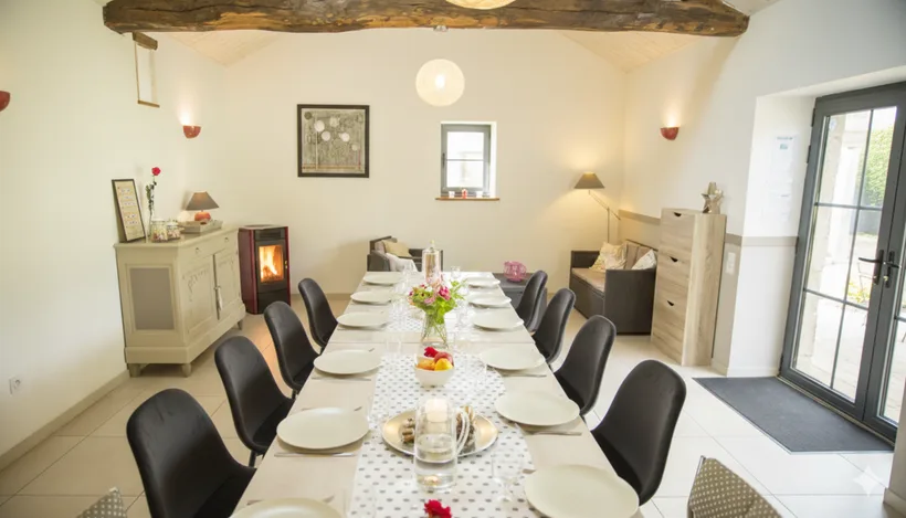 Salle à manger avec poutres apparentes et longue table pour les repas conviviaux