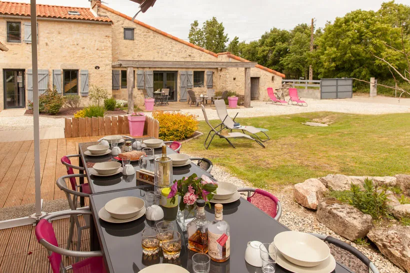 Terrasse extérieure avec grande tablée dressée pour un repas de groupe