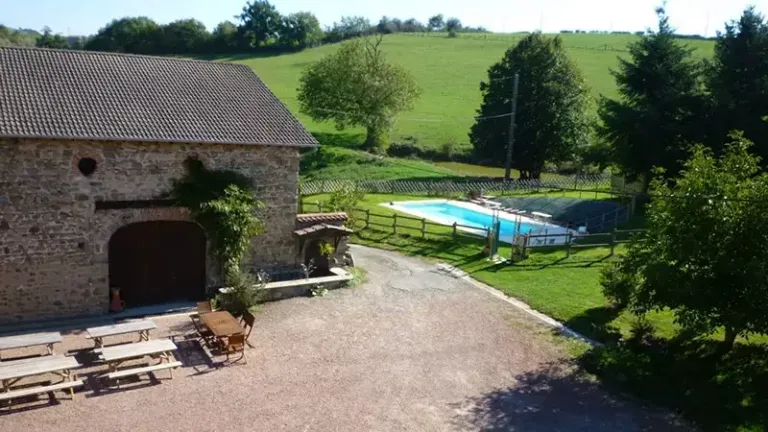 Piscine du domaine avec vue sur la grange en pierre