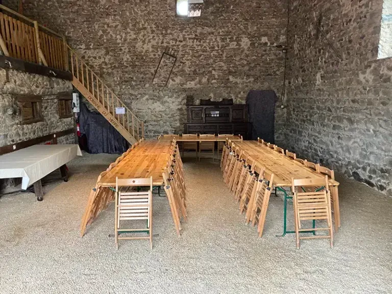 Longue tablée dressée dans la grange pour un repas de groupe