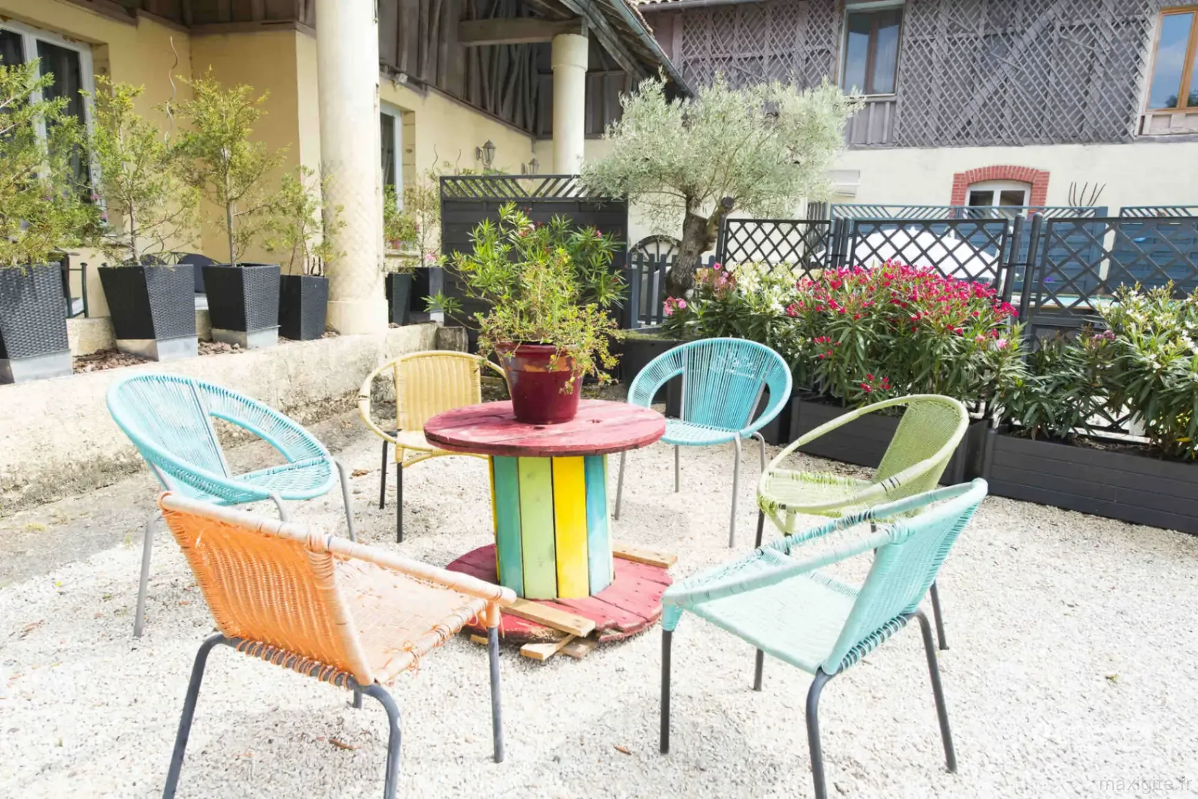Terrasse extérieure conviviale avec fauteuils colorés autour d'une table basse