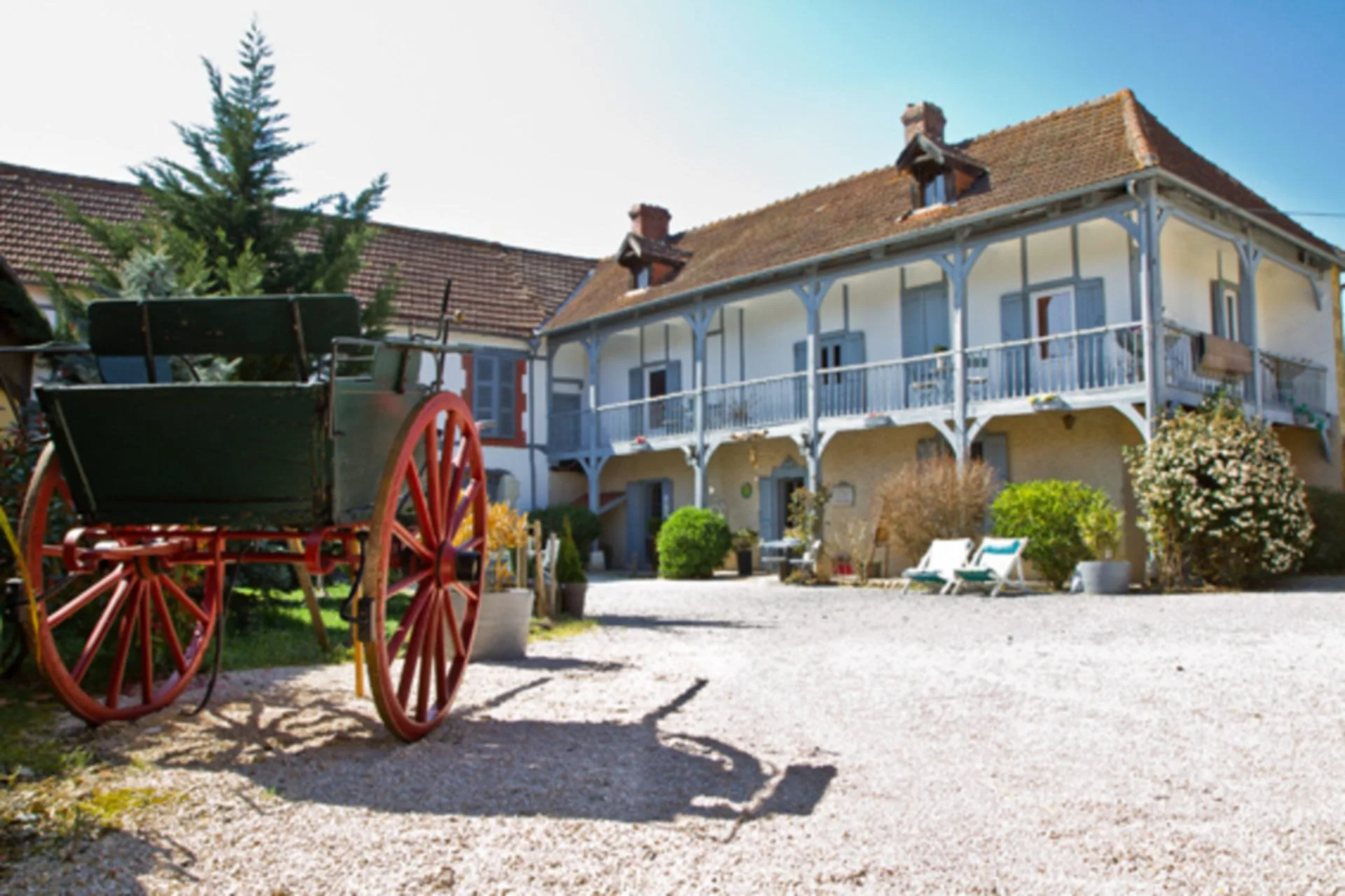 Gîte de groupe Domaine des Mousquetaires à Laas — Façade du domaine du XVIIIe siècle avec galerie à colombages et piscine, capacité 25 personnes