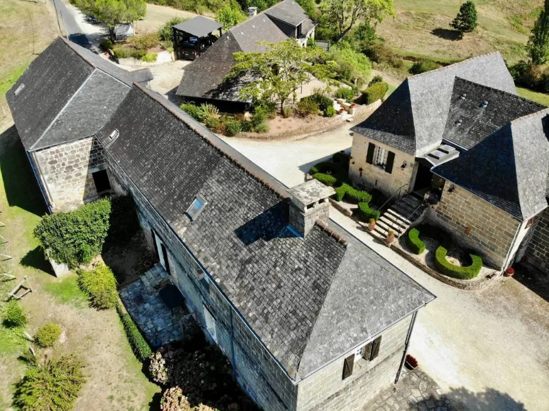 Vue rapprochée sur les toitures en lauze et la cour intérieure du domaine