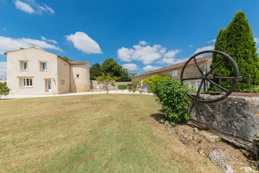 Gîte de groupe Le Vieux Monastère à Saint-Hilaire-de-Villefranche — Façade en pierre de l'ancien monastère avec pelouse et grande cour intérieure, capacité 40 personnes