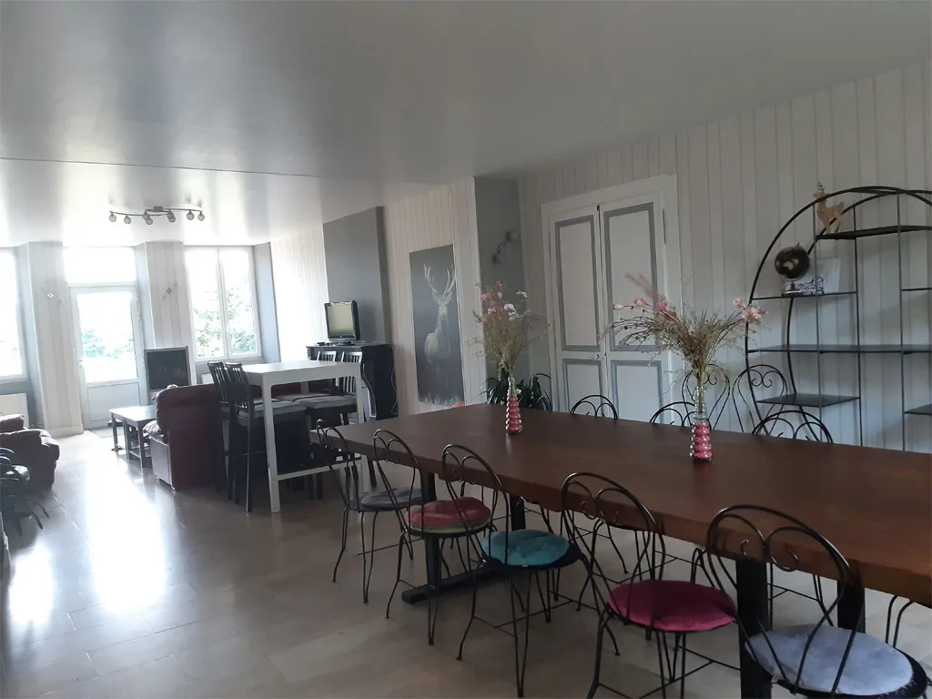 Grande salle à manger commune avec table conviviale pour les repas de groupe