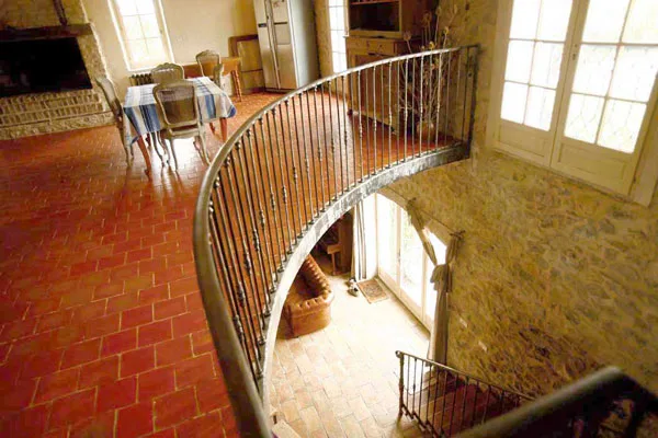 Escalier intérieur en fer forgé avec sol en carreaux de terre cuite