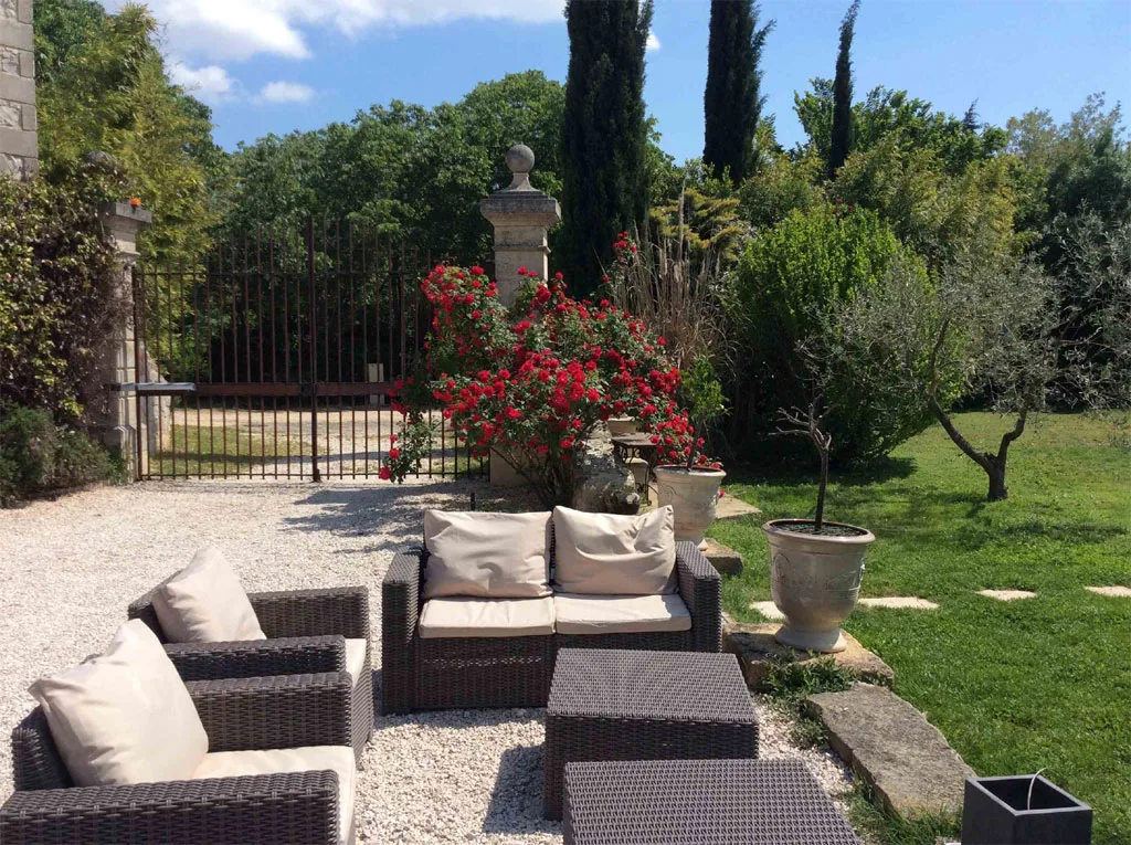 Terrasse extérieure ombragée avec salon de jardin et vue sur la piscine