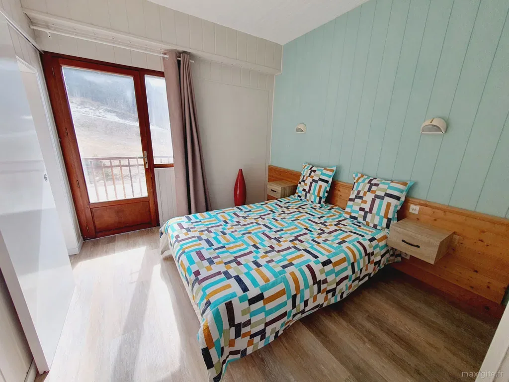 Chambre à la literie fleurie, ambiance chalet de montagne