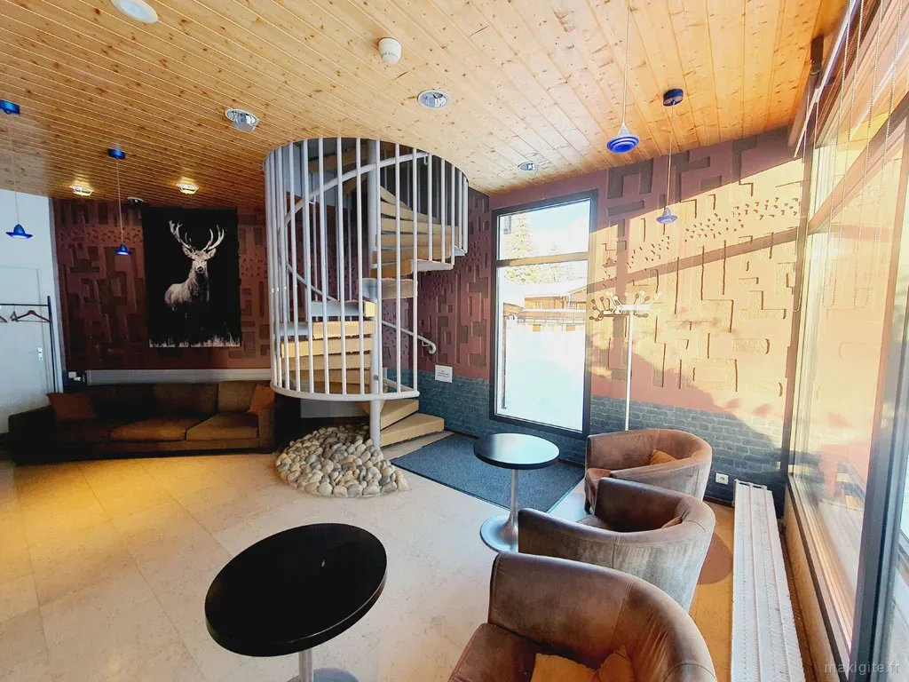 Salon cosy avec canapés en cuir noir et décoration montagnarde