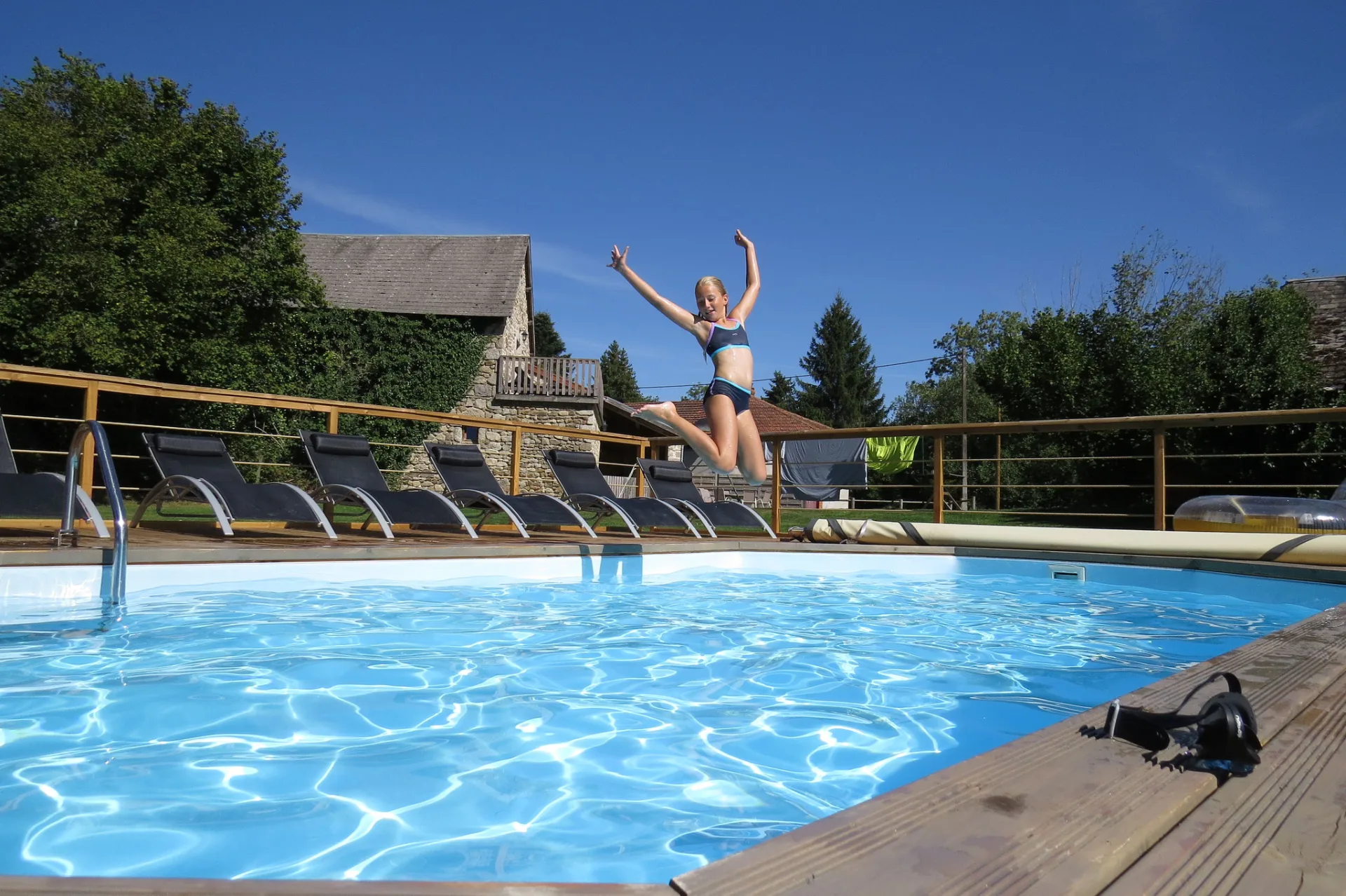 Piscine chauffée extérieure avec transats et vue sur la campagne du Puy-de-Dôme