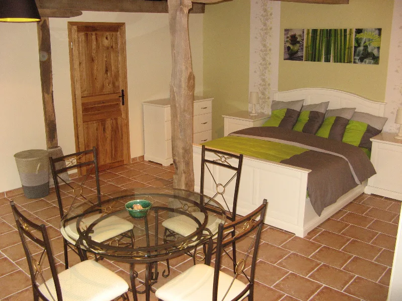 Chambre familiale avec grand lit double et coin repas rond