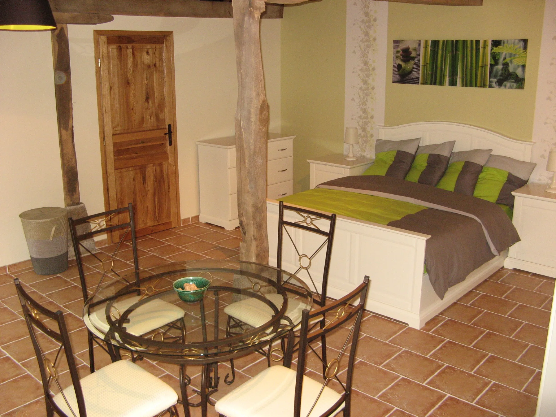 Chambre familiale avec grand lit double et coin repas rond