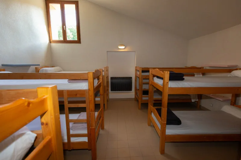 Dortoir de 12 couchages en lits superposés en bois sous les combles