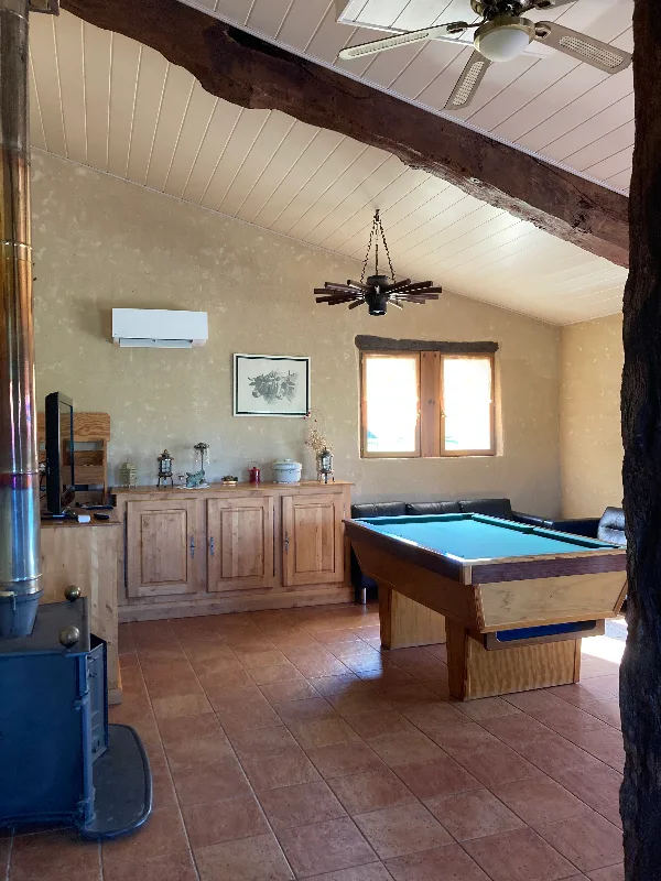Salon avec cheminée, poêle à bois et billard pour les soirées entre convives