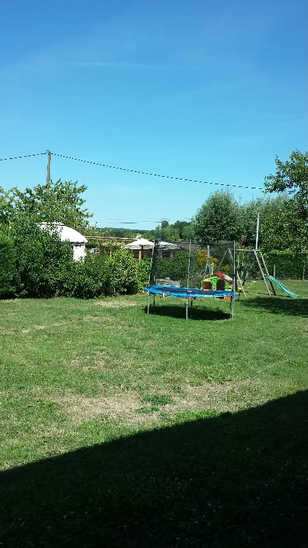 Grand jardin arboré avec trampoline pour les enfants et espace de détente