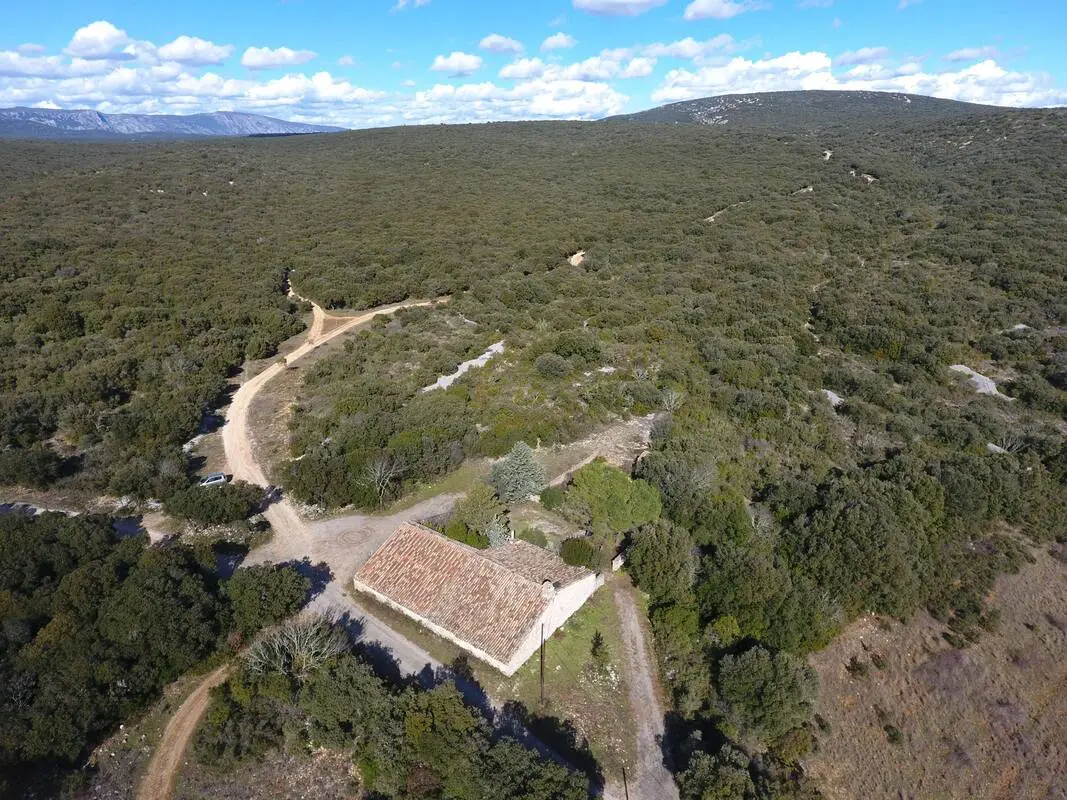 Gîte de groupe La Bergerie des Rêves à Puéchabon — Vue aérienne de la bergerie en pierre isolée au cœur de la forêt méditerranéenne, capacité 15 personnes