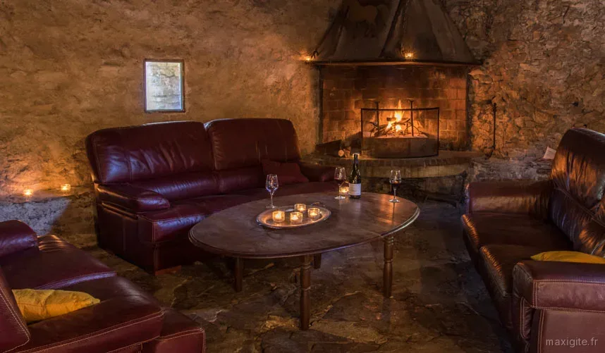 Salon en pierre avec cheminée et canapés en cuir pour les soirées d'hiver