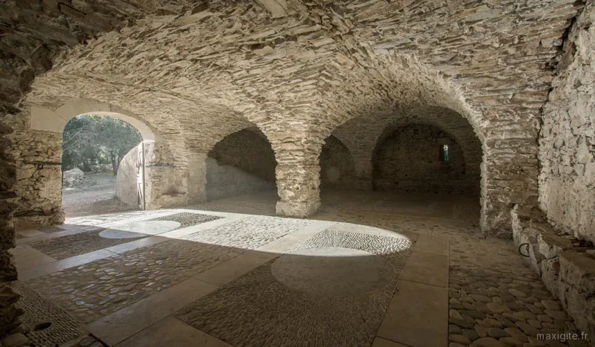 Grande salle voûtée en pierre de 80 m² avec sol en galets, espace de vie principal