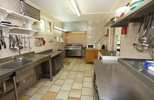 Cuisine professionnelle équipée avec grand plan de travail pour cuisiner en groupe
