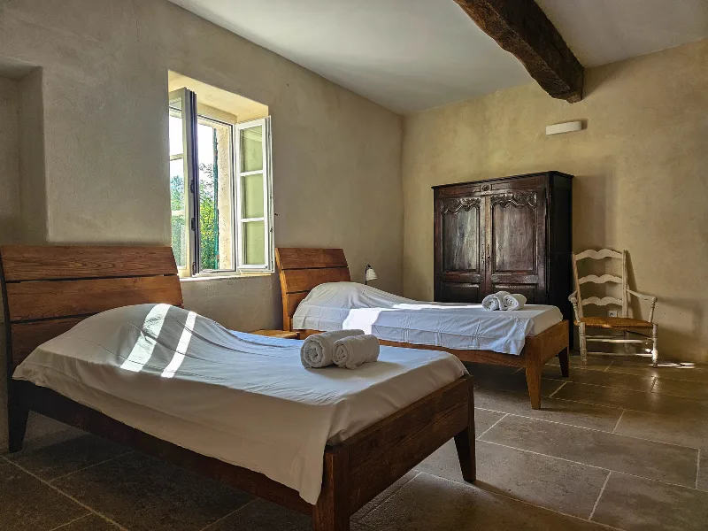 Chambre lumineuse du premier étage avec lits et poutres apparentes