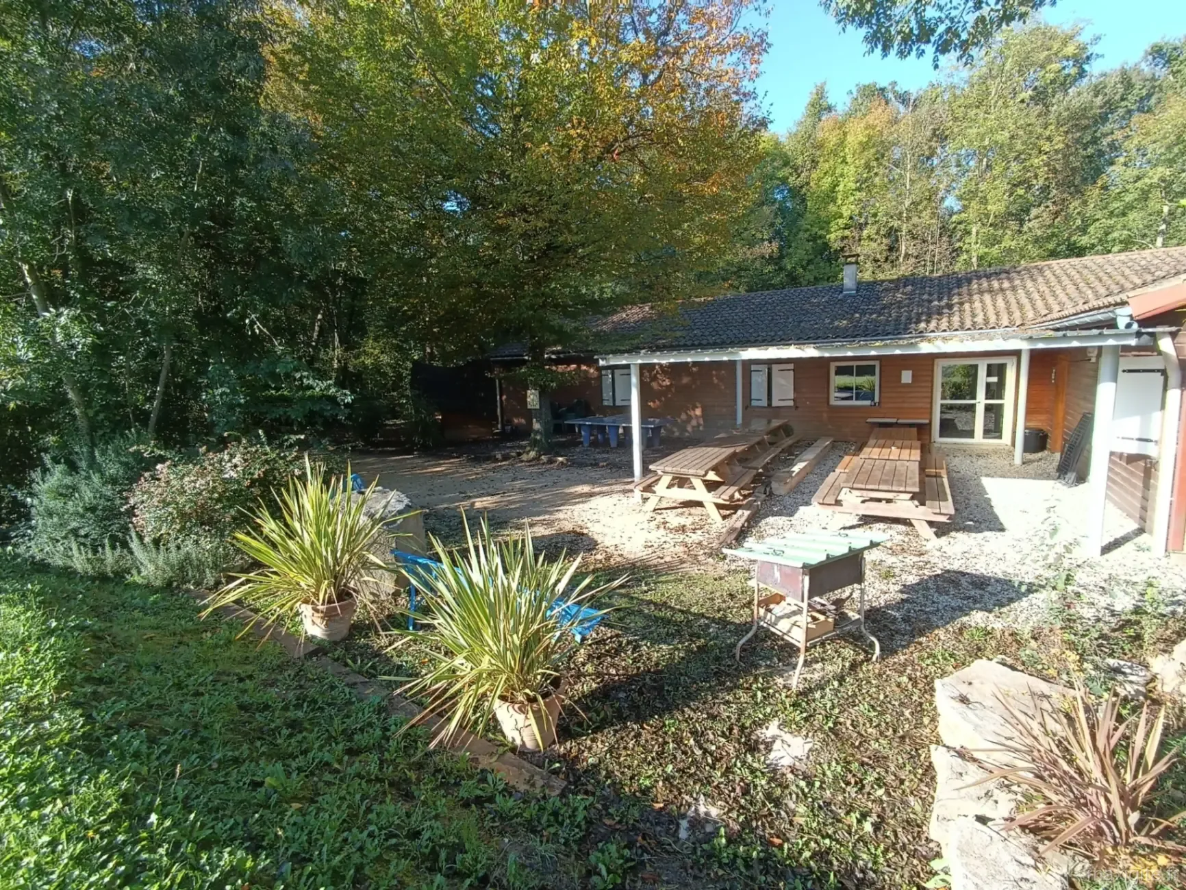 Terrasse extérieure couverte avec tables de pique-nique en bois vue Vercors