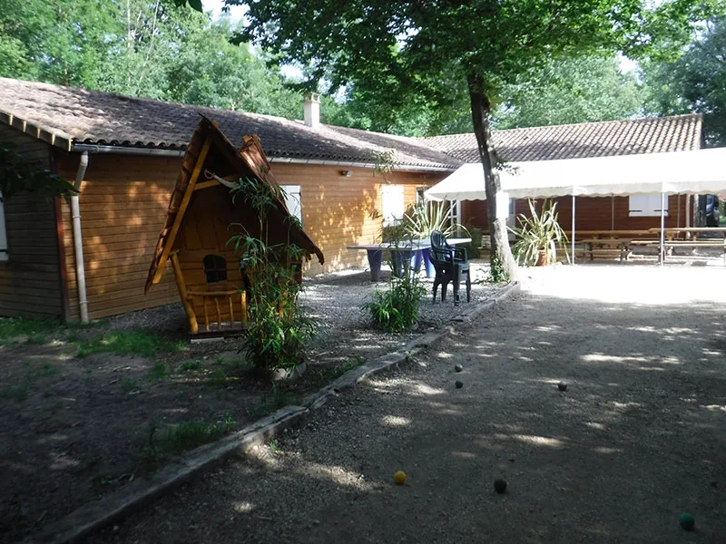 Vue d'ensemble du domaine avec terrain de pétanque, cabane de jardin et préau couvert