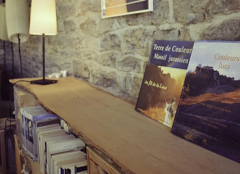 Meuble bibliothèque en bois avec livres et magazines dans un espace salon en pierres