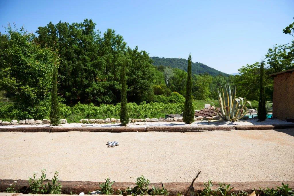Terrain de pétanque du domaine avec cyprès et vue sur les collines varoises
