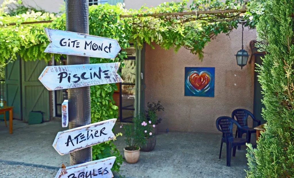 Panneaux directionnels du domaine indiquant le gîte Monet, la piscine et l'atelier