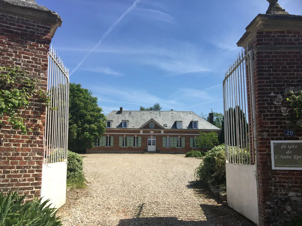 Gîte de groupe Le Gîte de l'Aube Epine à Haute-Épine — Portail d'entrée en brique avec grille en fer forgé et allée de gravier menant au manoir, capacité 45 personnes