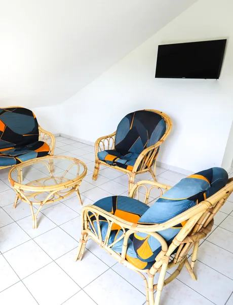 Coin détente avec fauteuils en rotin et coussins bleus dans le salon lumineux
